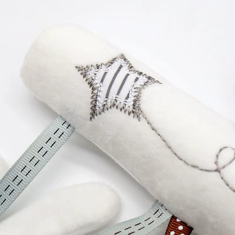 White fabric roll with embroidered design on a white background