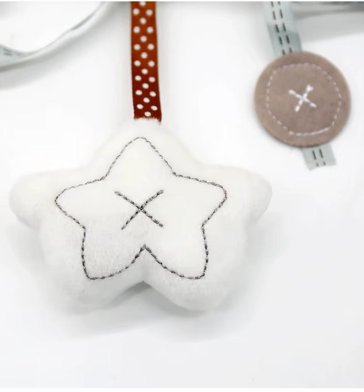 White star-shaped toy with black stitching on a white background