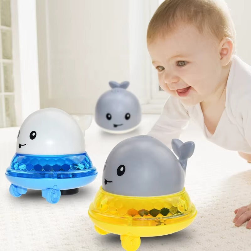Three colorful whale-shaped toys on a light surface with a baby in the background.