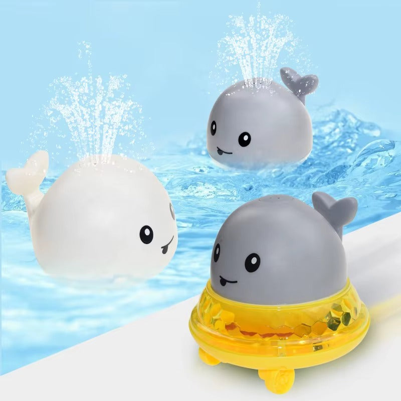 Three cartoon-style whale toys with water sprays in a pool setting