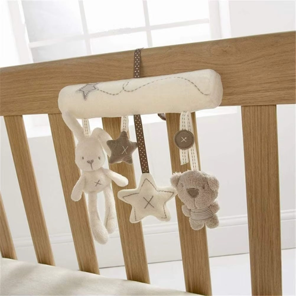 Baby crib mobile with plush toys and stars hanging from a wooden crib
