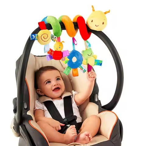 Baby in a car seat with colorful toy hanging above